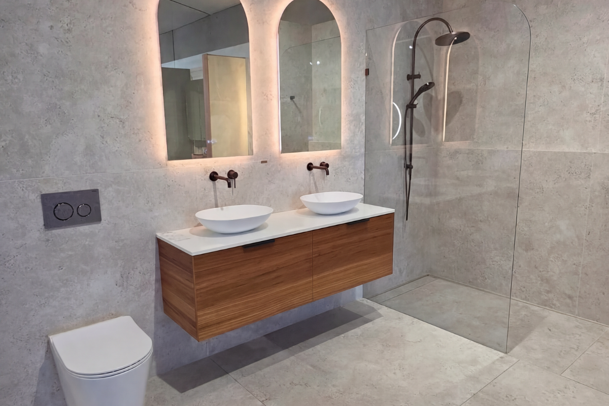 Modern bathroom display with timber vanity, grey tiles, LED mirrors, toilet and shower at Eos Bathware Mornington 